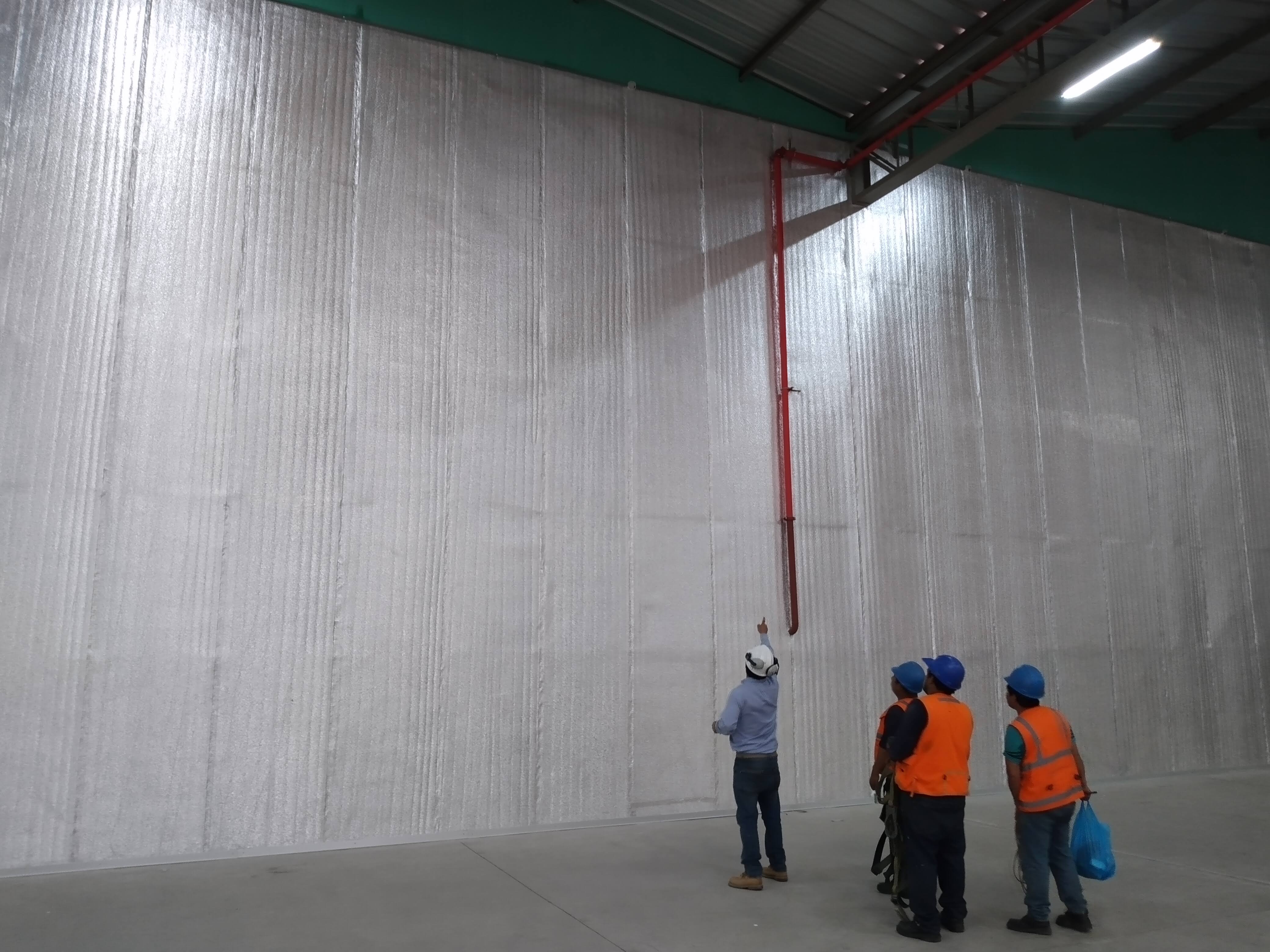 Muro de nave industrial forrado con manta termoacústica de fibra de vidrio