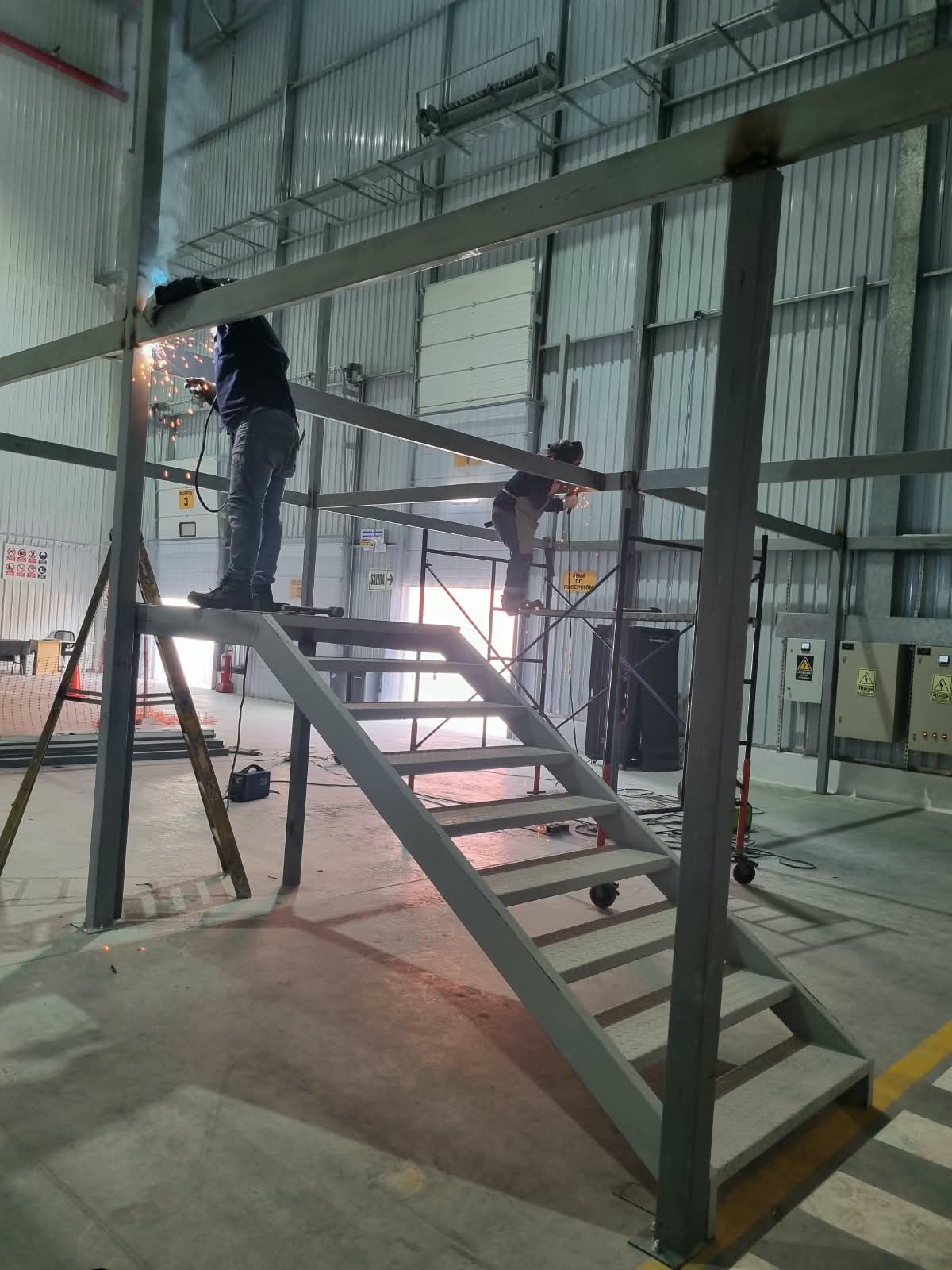 Soldadura de vigas de mezzanine dentro de nave industrial