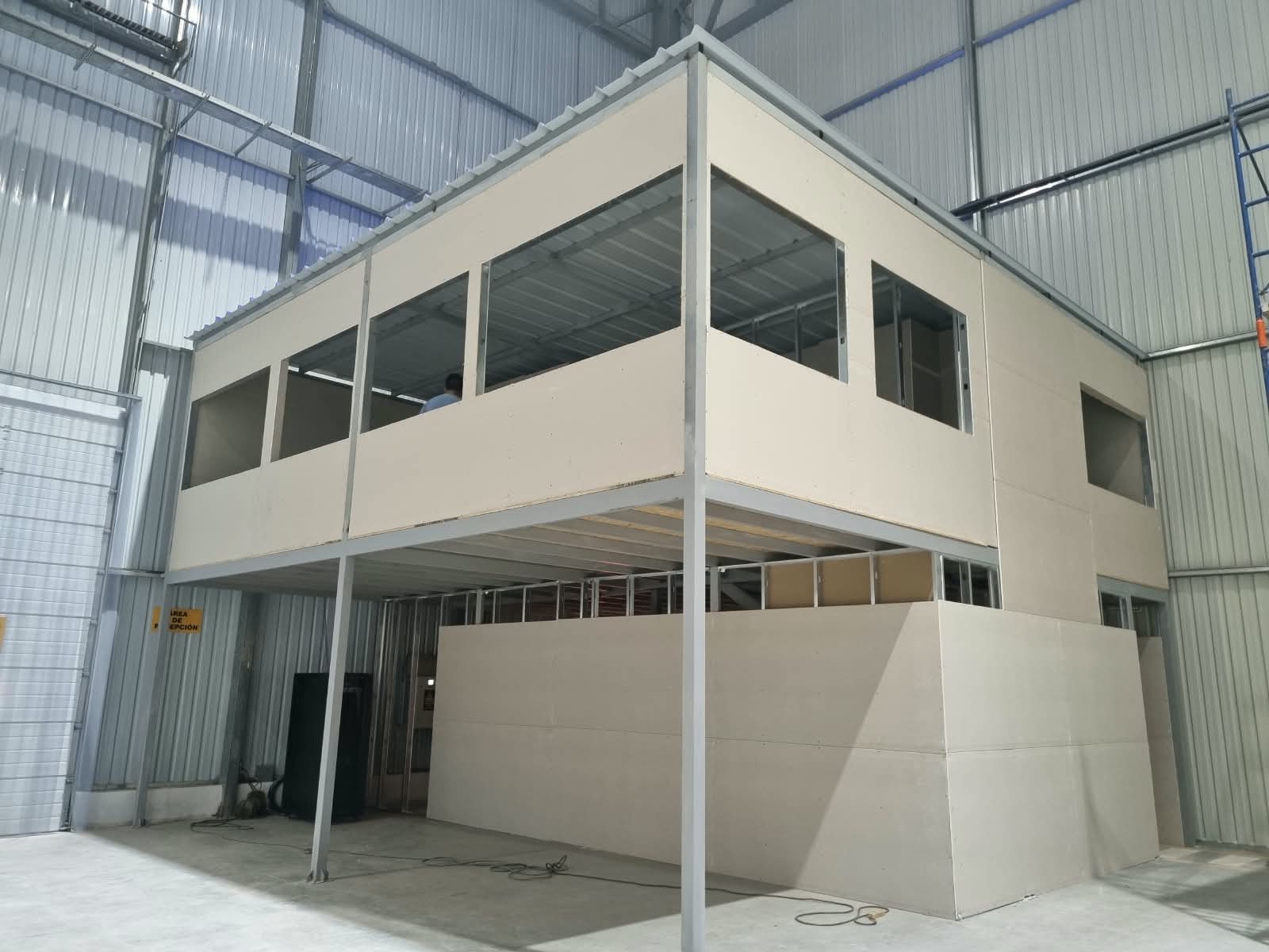 Oficina de dos niveles terminada dentro de nave industrial